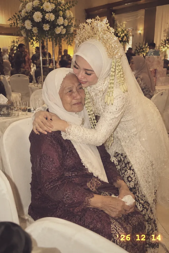 Nadia memeluk neneknya yang duduk di kursi tamu